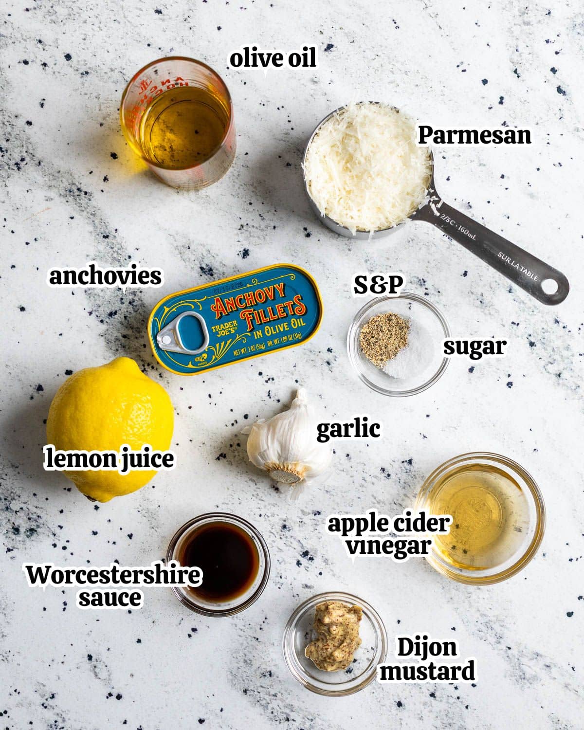 Text-labeled Caesar vinaigrette ingredients in separate containers.