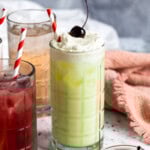 An Italian pistachio cream soda topped with whipped cream and a cherry.