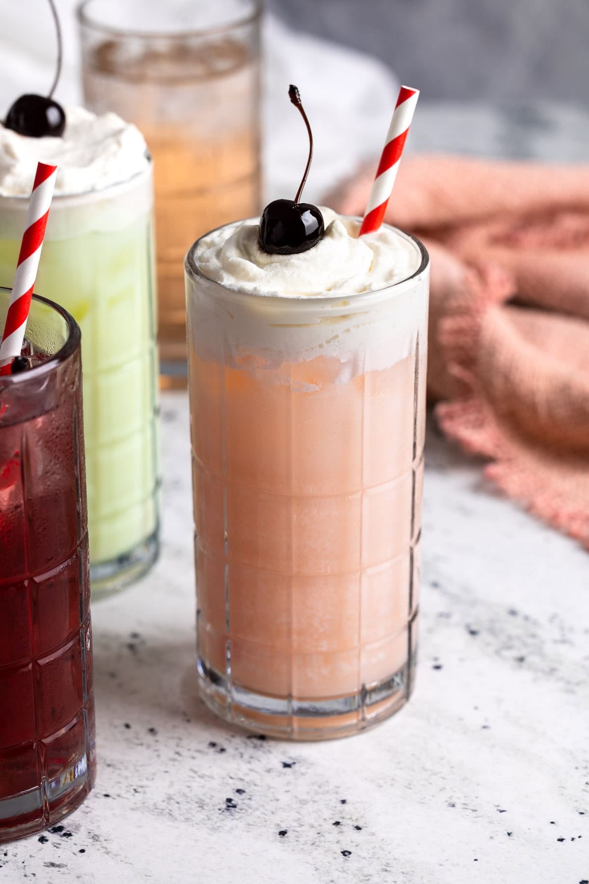 An Italian peach cream soda topped with whipped cream and a cherry.