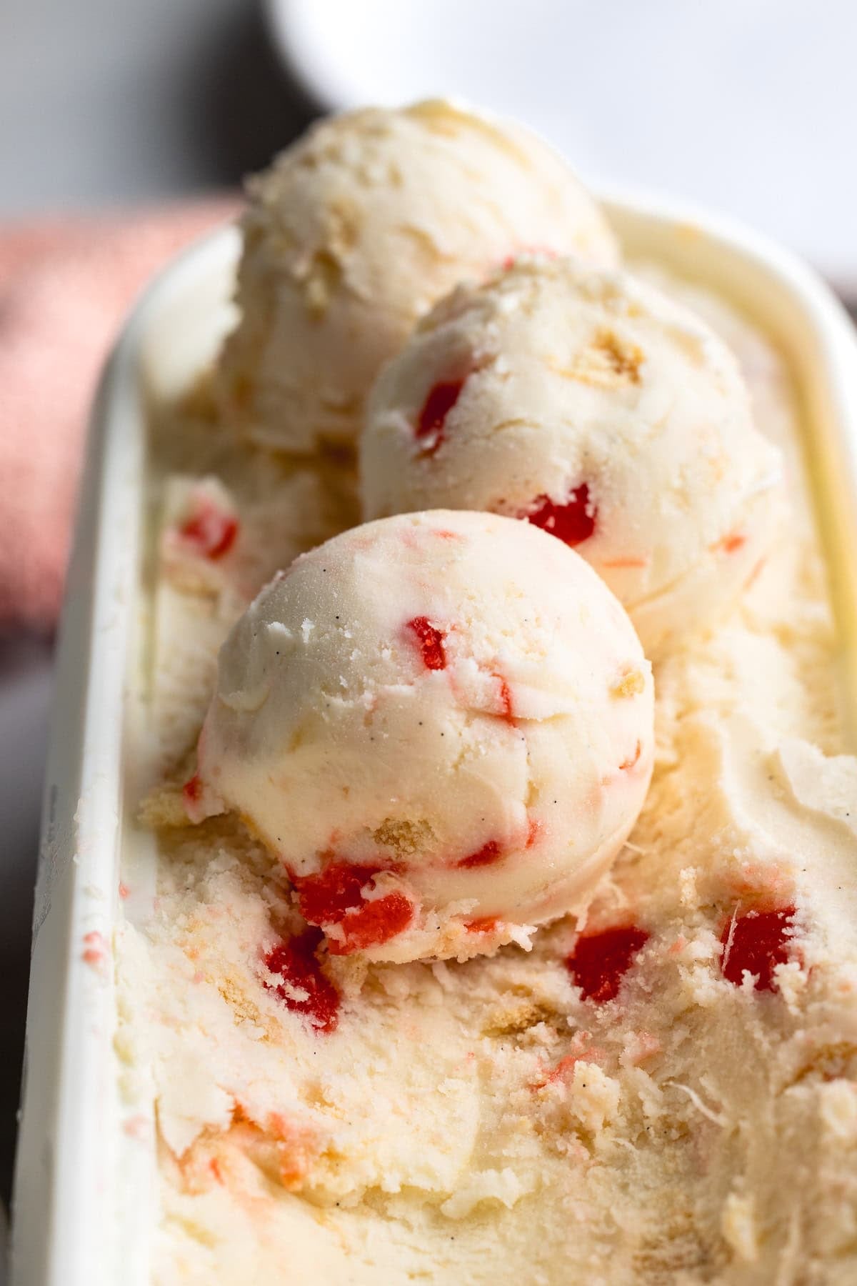 Scoops of pineapple upside down cake frozen yogurt in a storage container.