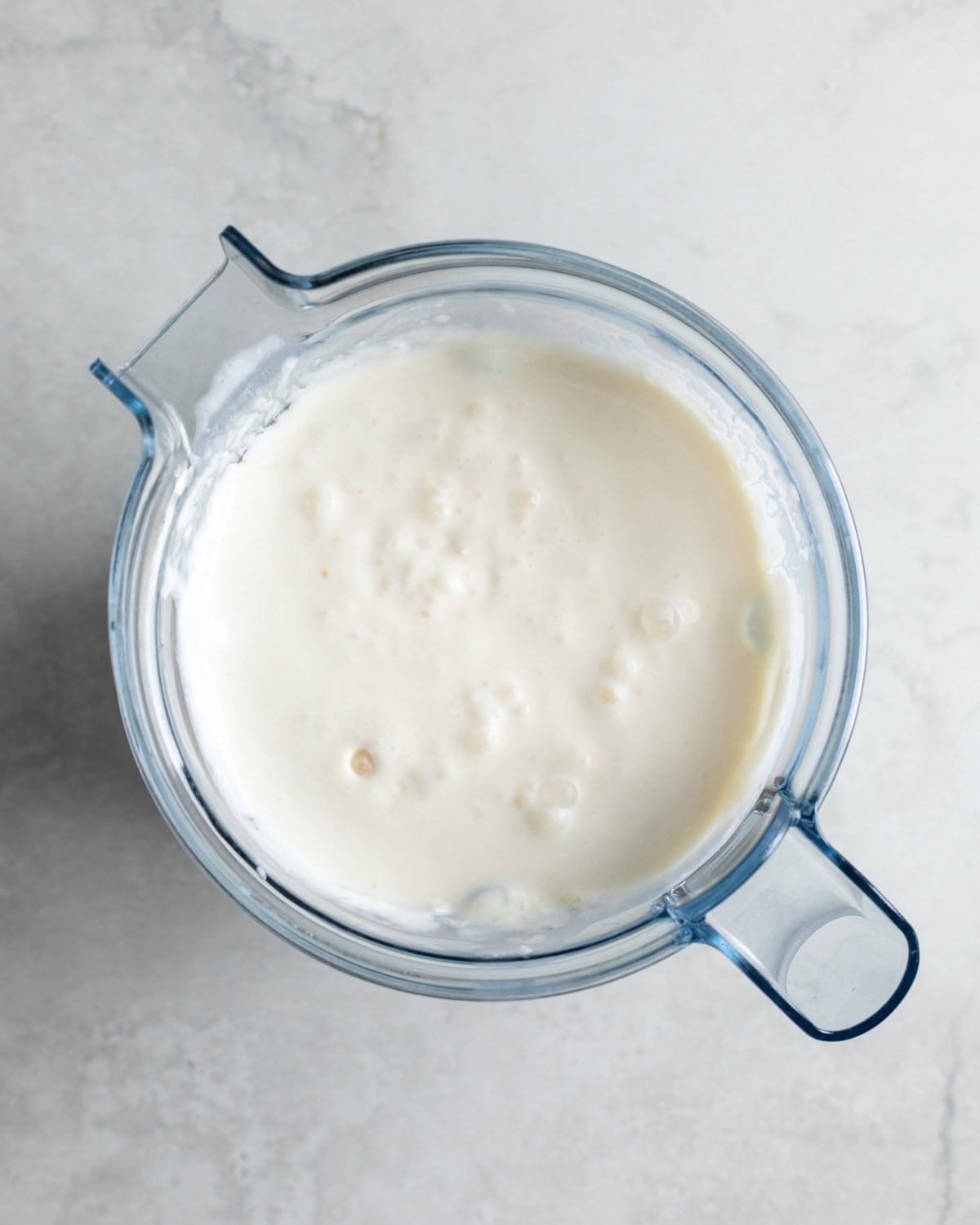 The pineapple frozen yogurt ingredients blended smooth in a blender.