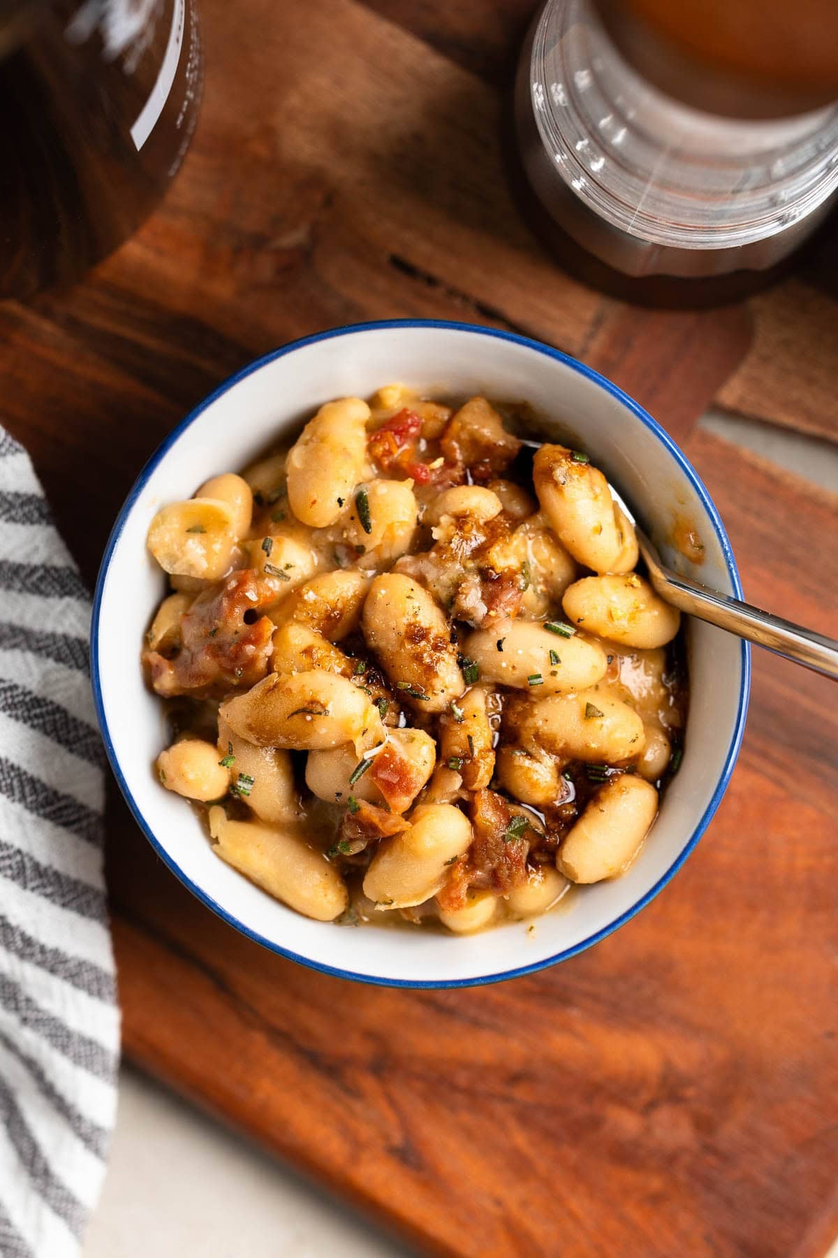 A serving of creamy Tuscan white beans in a bowl drizzled with balsamic vinegar.