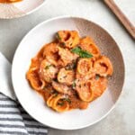 A serving of Greek yogurt vodka sauce coating pasta in a shallow bowl.