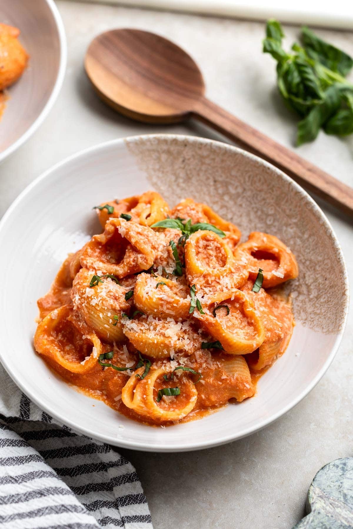 Greek yogurt vodka sauce served over pasta in a plate garnished with basil.