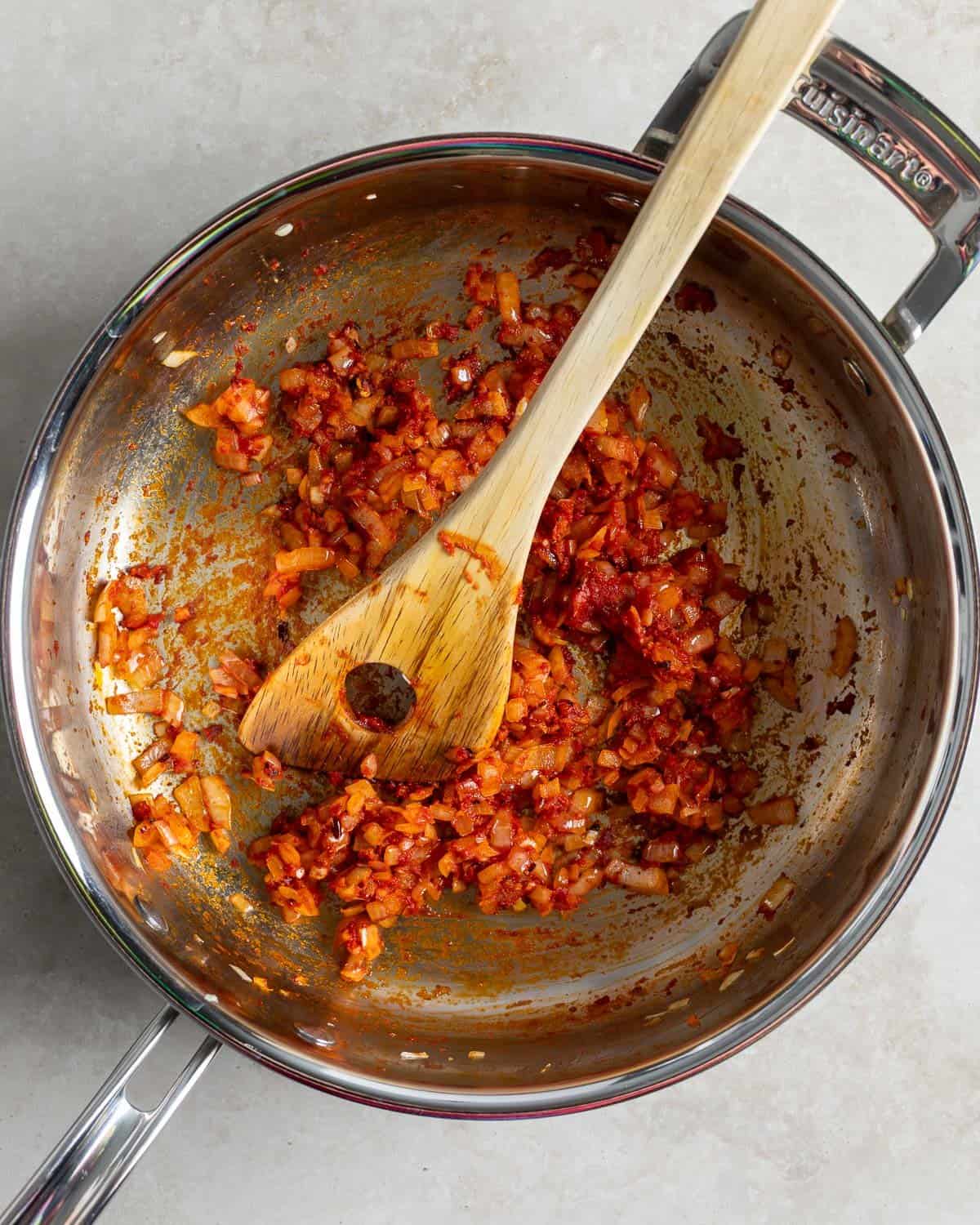 Onion, garlic, and tomato paste cooking in a pan.