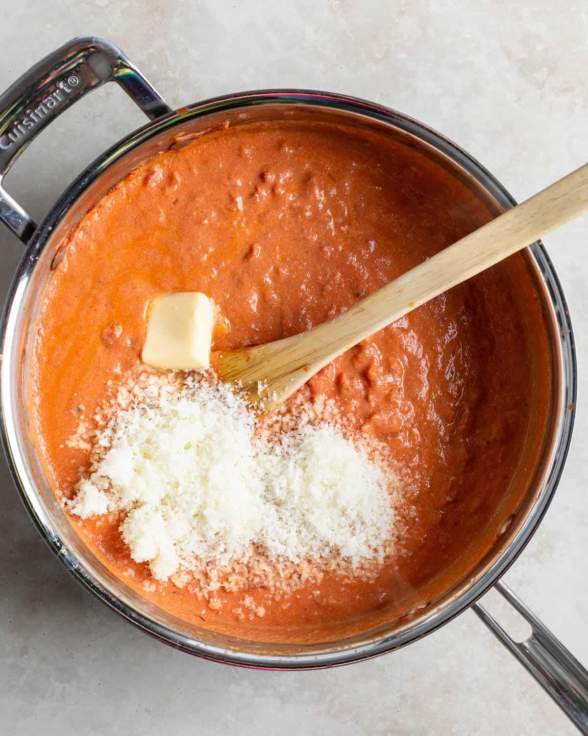 Pecorino and the remaining butter being stirred into the pan of Greek yogurt vodka sauce.