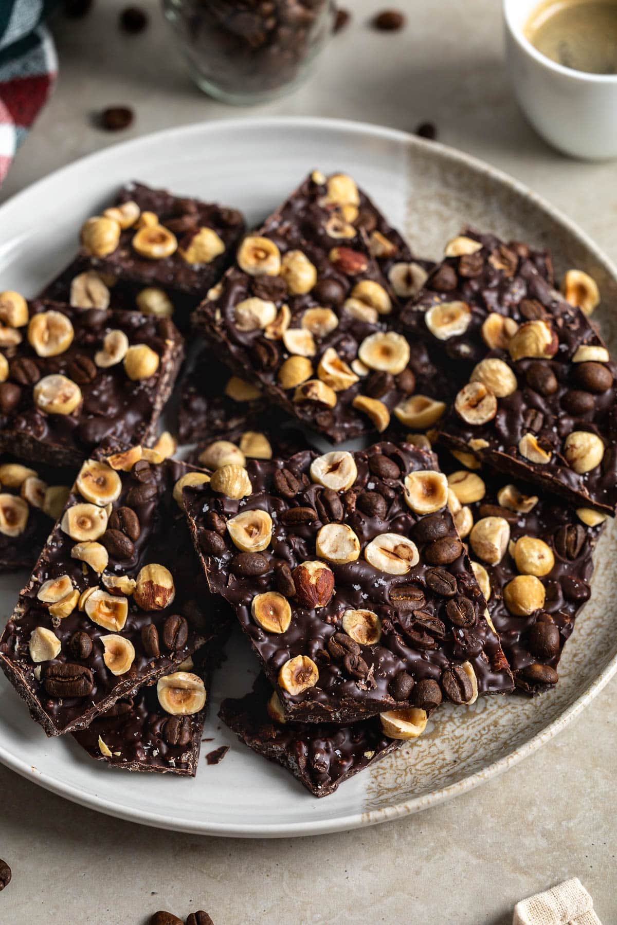 Sliced espresso bean bark on a plate near a small cup of espresso.