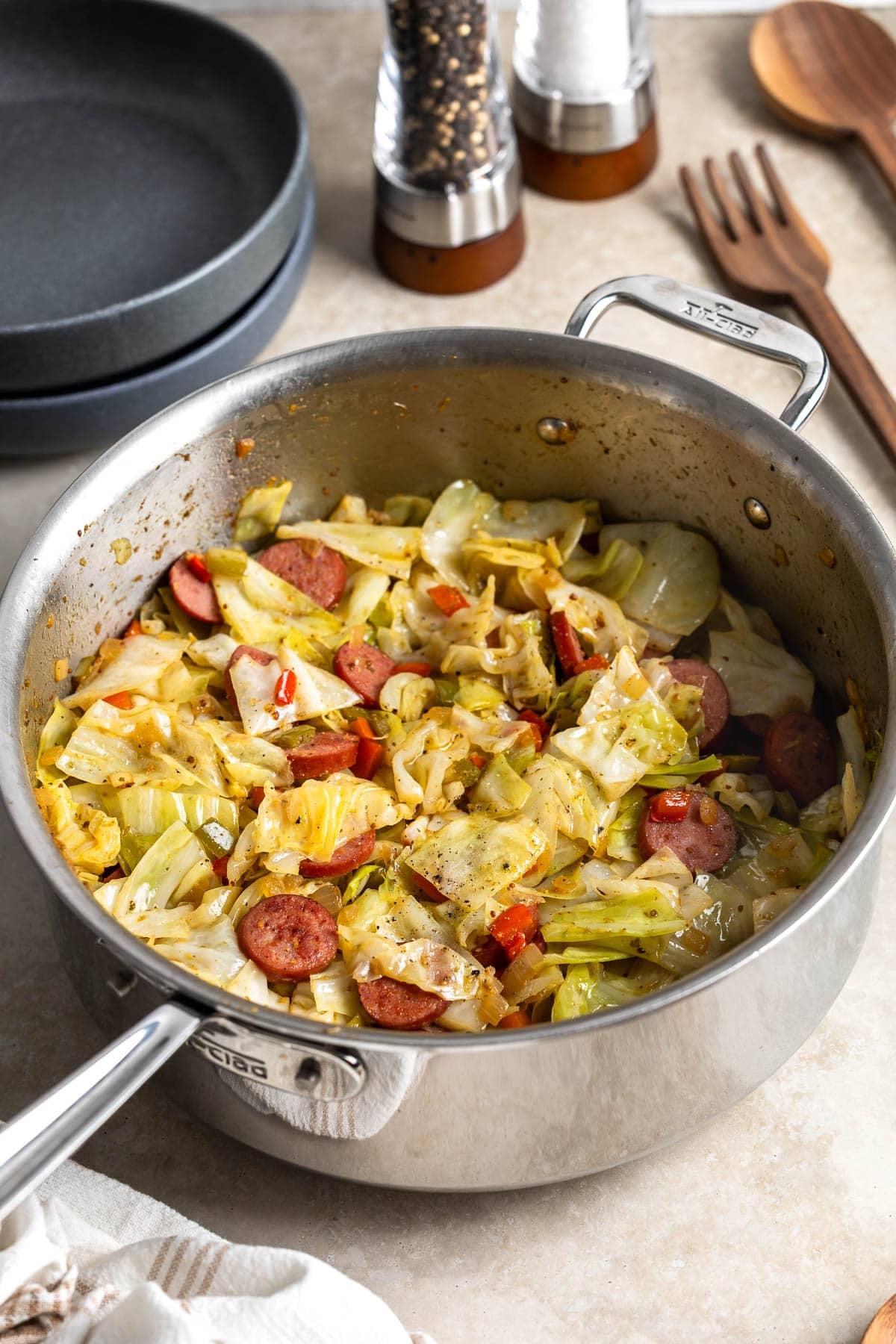 A sauté pan of fried cabbage and smoked sausage.