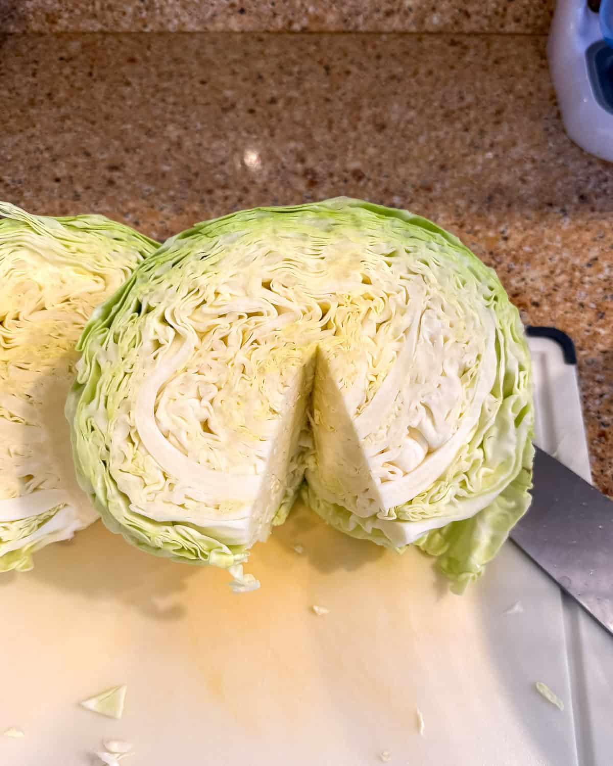 A halved green cabbage head with the core stem removed.