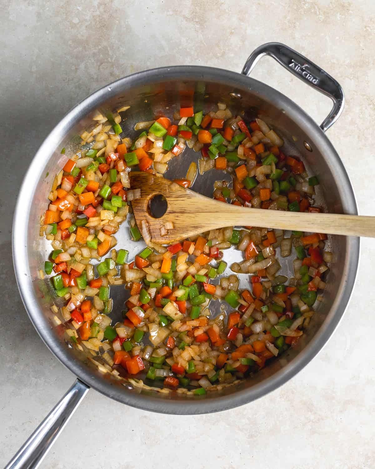 Onion and bell pepper sautéing in a pan.