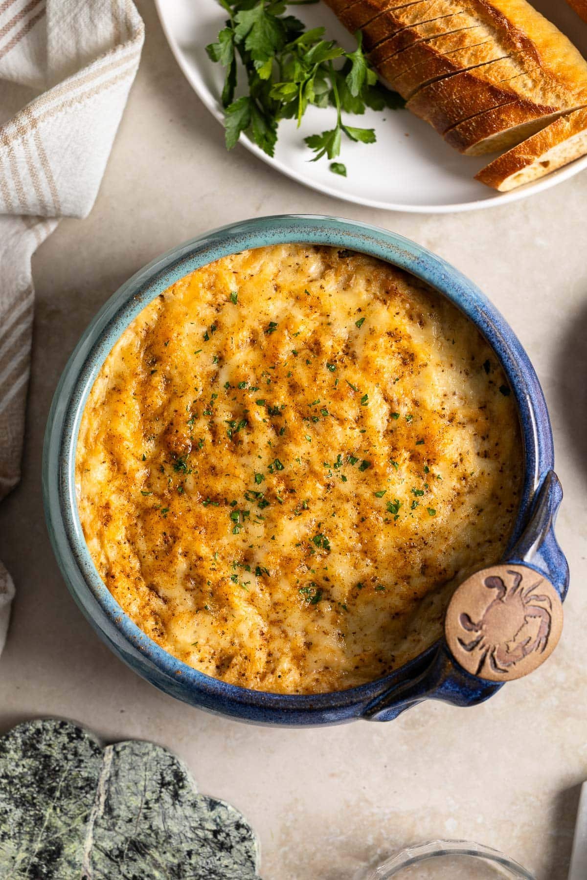 Baked crab dip in a stoneware bowl.