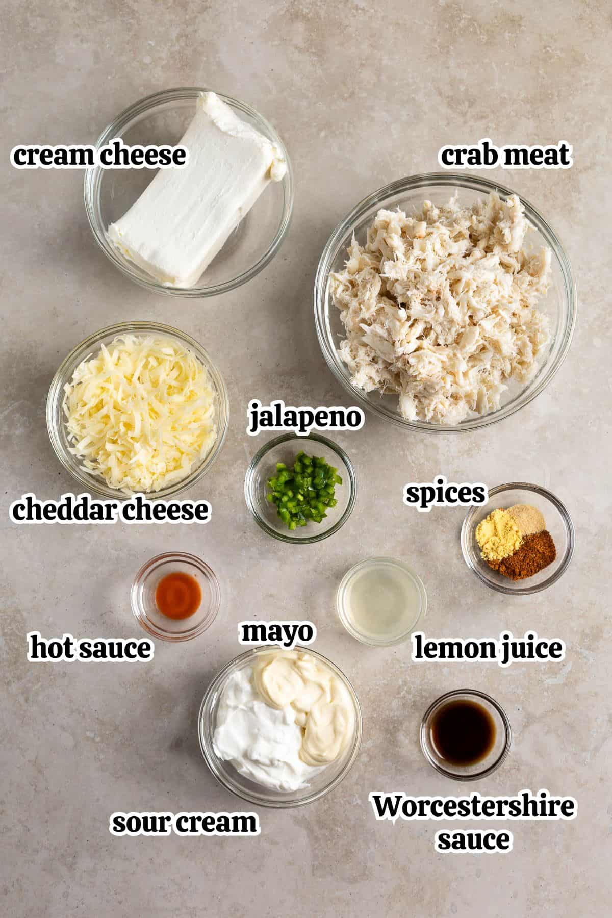 Text-labeled ingredients necessary for crab dip in separate bowls.