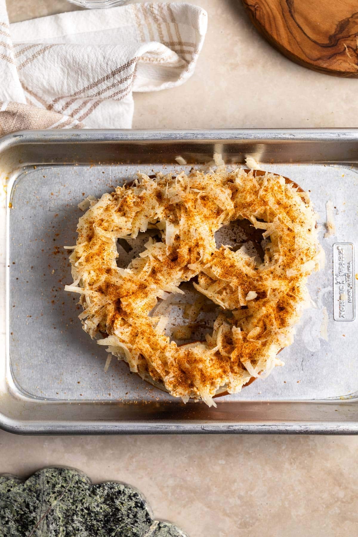 Crab dip and shredded cheddar on top of a soft pretzel before baking.