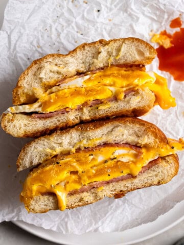 A Taylor ham, egg, and cheese sandwich with jammy eggs, drippy cheese, and hot sauce.