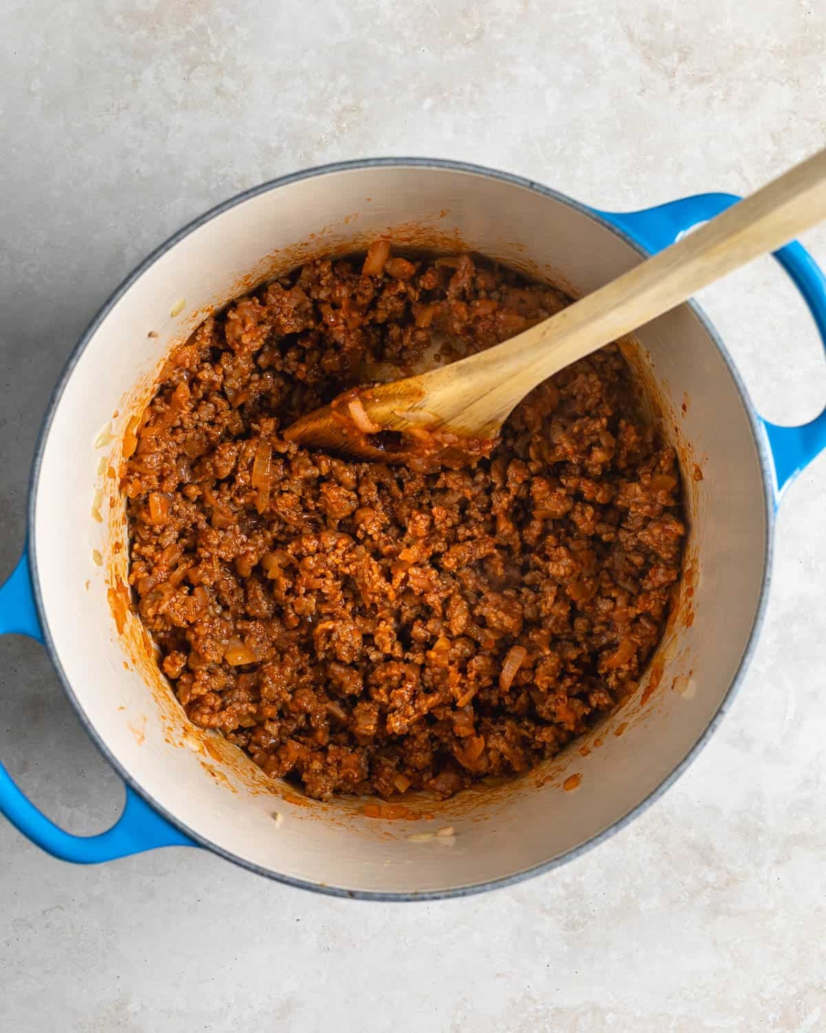 Tomato paste, garlic, and seasoning stirred into the sausage and onion.