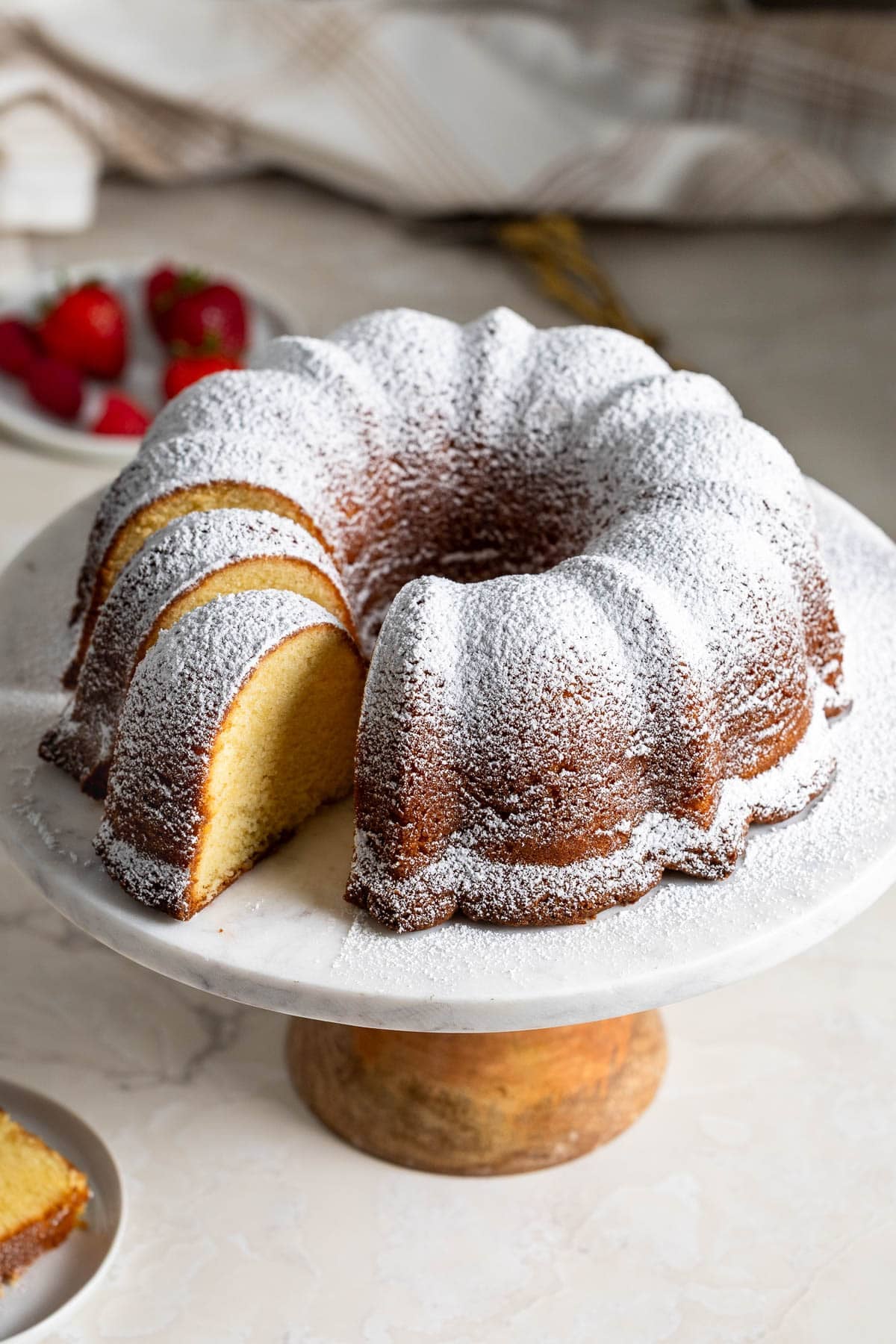 A partially-sliced Philly fluff cake on a cake stand.