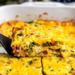 A side profile view of a wedge of ricotta egg bake being lifted out of the pan by a spatula.
