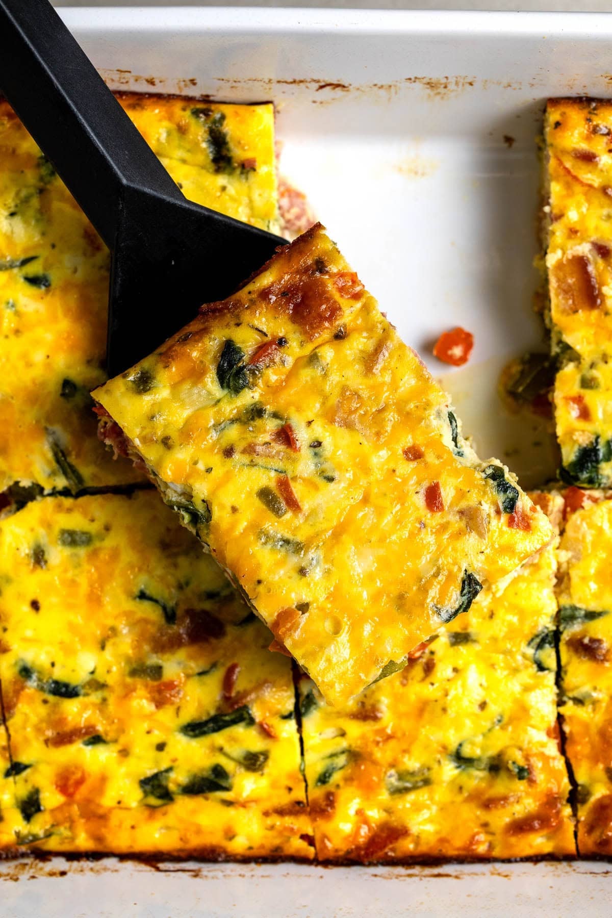 A top-view of the sliced egg bake in the pan being served.