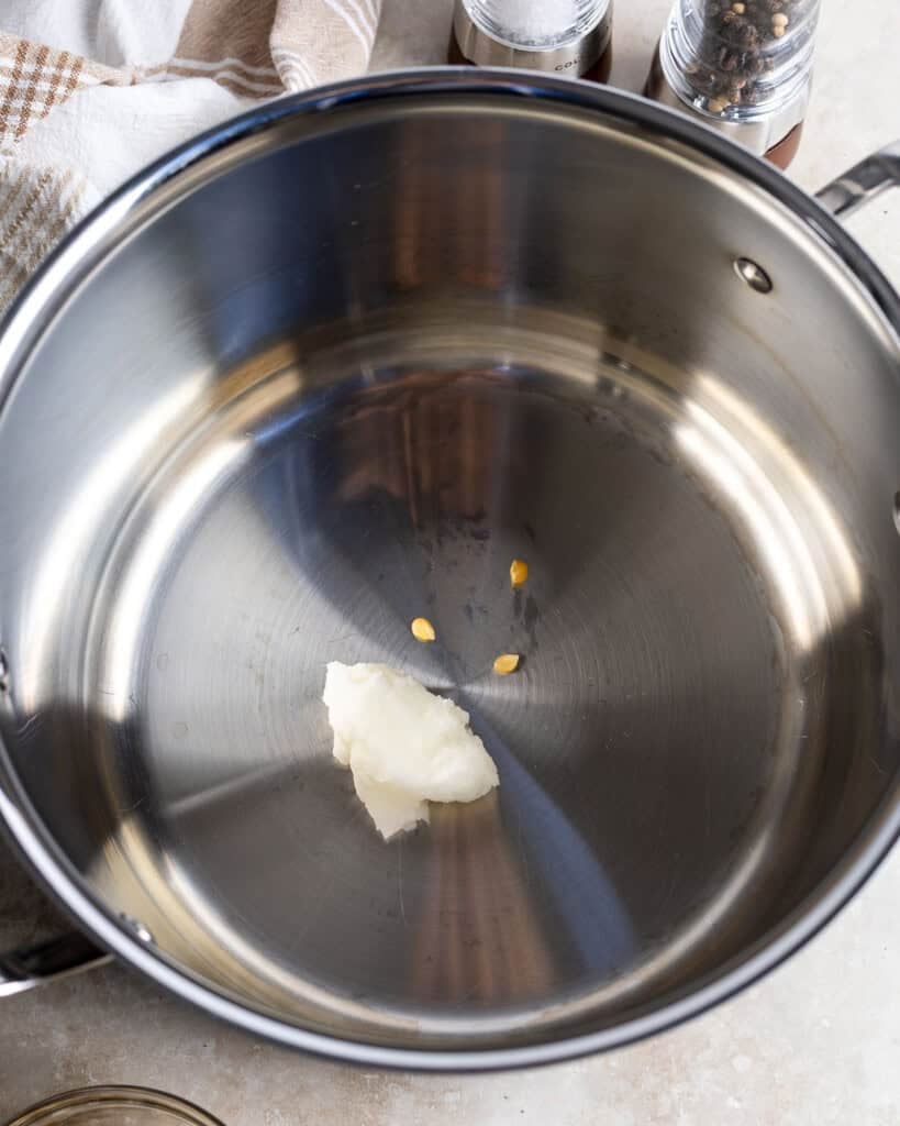 Coconut oil and three popcorn kernels in a large pot.