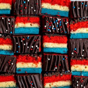 Red white and blue rainbow cookies in an alternating side-profile and top pattern.