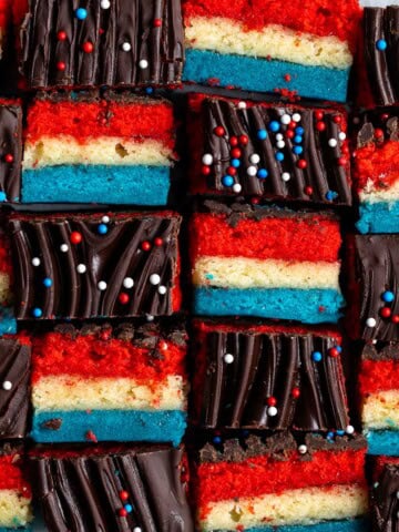 Red white and blue rainbow cookies in an alternating side-profile and top pattern.