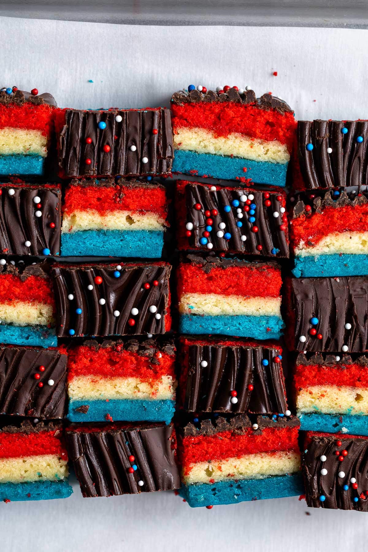 Red white and blue rainbow cookies in an alternating side-profile and top pattern.