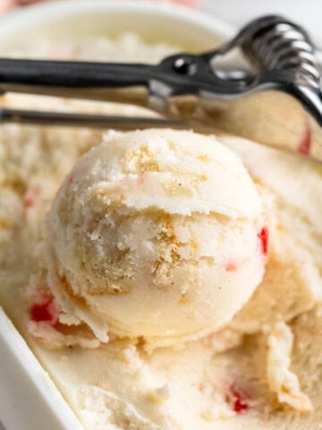 Scoops of pineapple upside down cake frozen yogurt in a storage container.