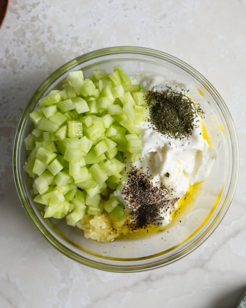 Yogurt sauce ingredients added to a bowl.