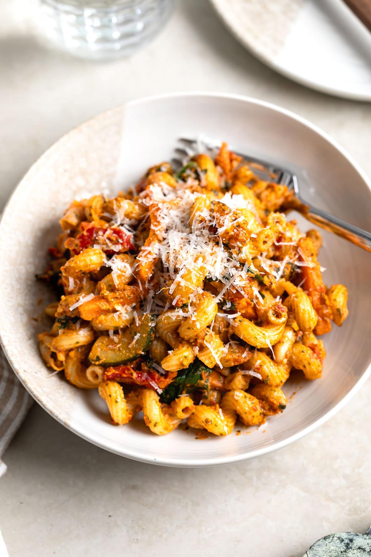 Sun-dried tomato pesto on cavatappi pasta and vegetables and beans, garnished with Parmesan.